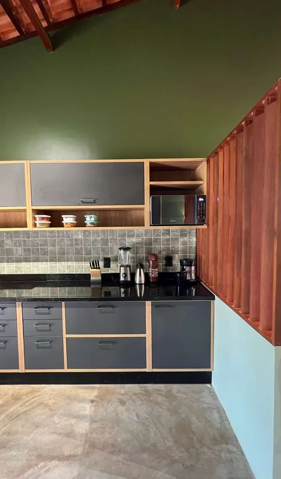 Cozinha com treliça de madeira avermelhada, azulejos claros e parede verde