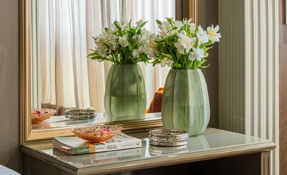 Vasos verdes com flores brancas sobre a penteadeira