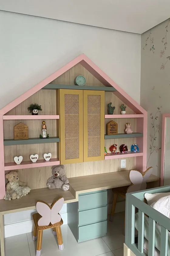 Quarto infantil com estante em forma de casinha rosa e escrivaninha