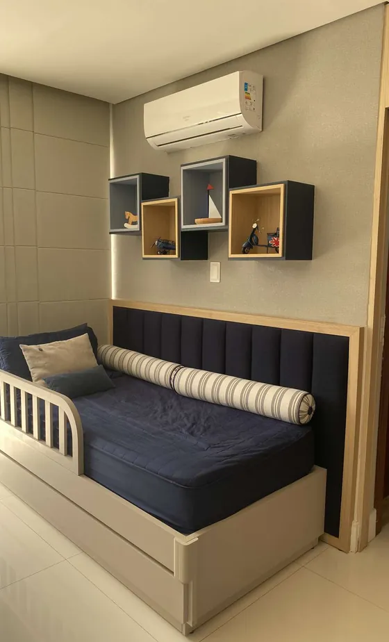 Quarto infantil com bicama azul-marinho e nichos na parede