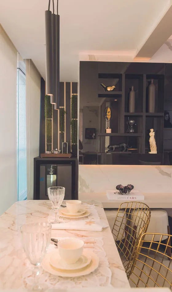 Varanda com mesa de mármore e coluna de nichos pretos